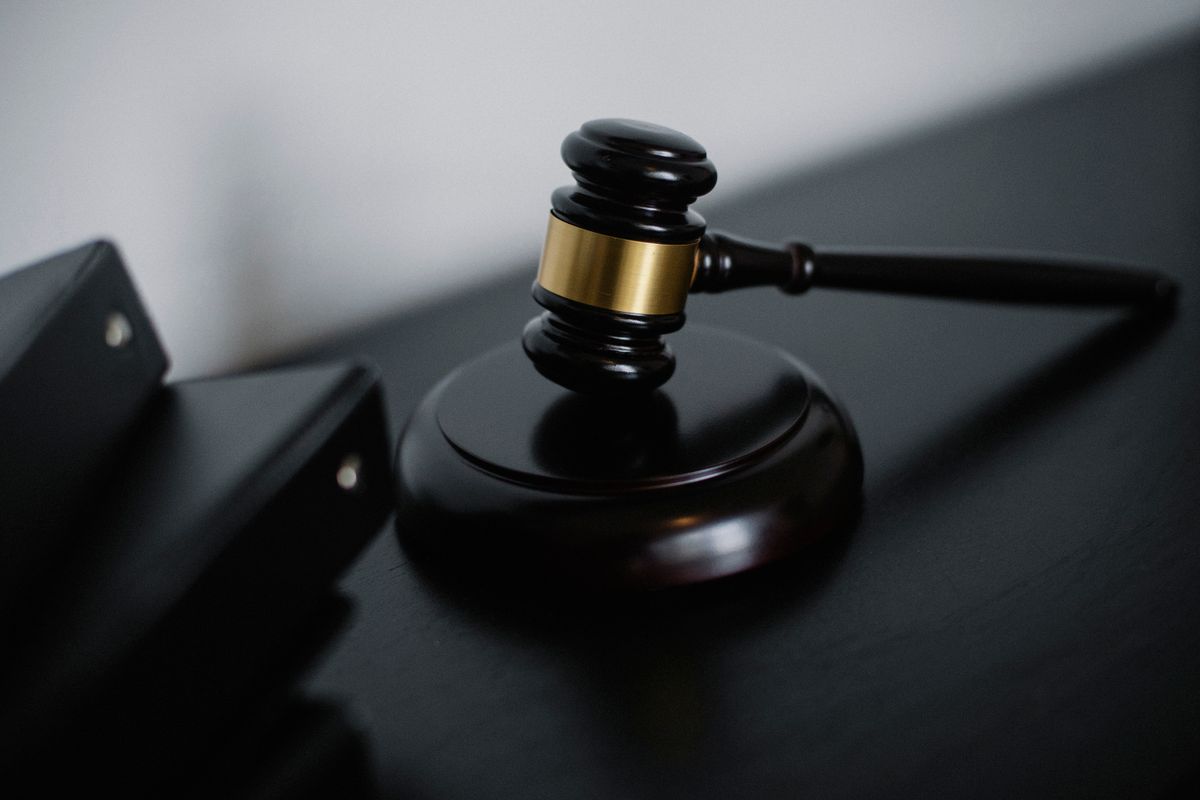 Business owner signing a contract at a desk with a lawyer