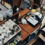 Cafe owner working behind the counter of a small coffee shop, an employer affected by payday super