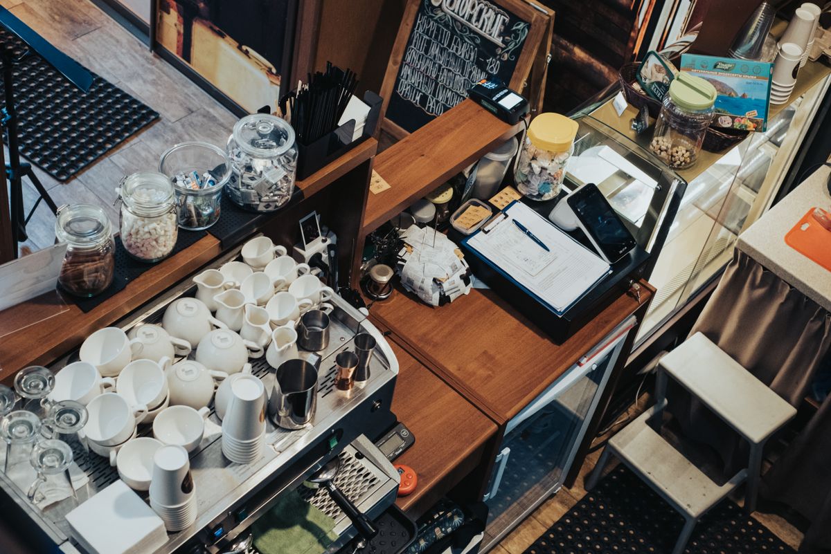 Cafe owner working behind the counter of a small coffee shop, an employer affected by payday super