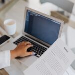 Business owner reviewing a privacy policy document beside a laptop