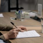 Business owner signing a standard form contract at a desk
