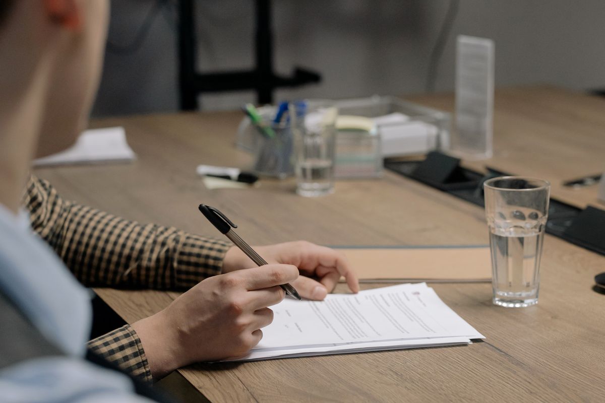 Business owner signing a standard form contract at a desk